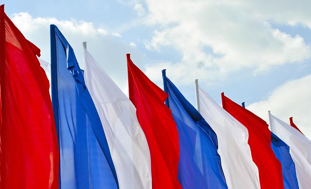 red, white, and blue flags on sky background