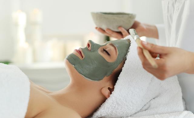 woman getting face mask at spa